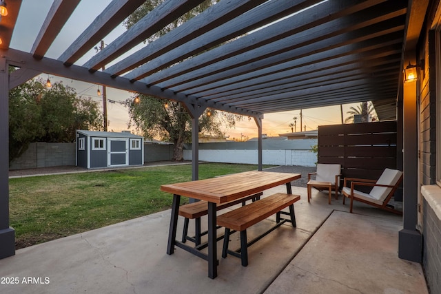 patio terrace at dusk with a yard, a shed, and a pergola