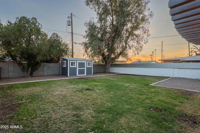 yard at dusk featuring a storage unit