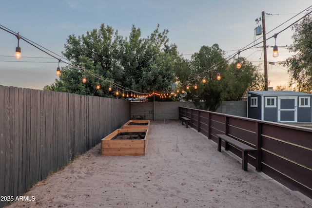 yard at dusk featuring a storage unit