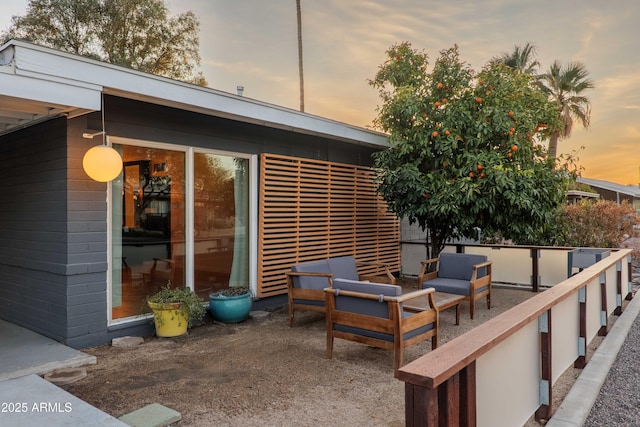 patio terrace at dusk featuring an outdoor hangout area