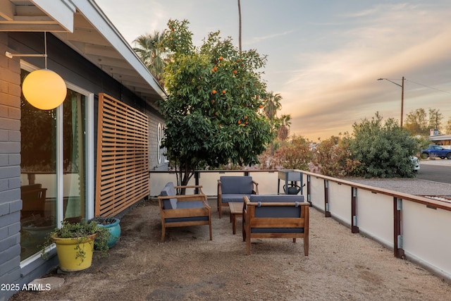 patio terrace at dusk featuring an outdoor hangout area