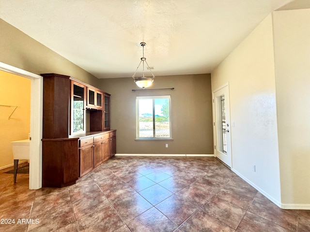 kitchen featuring dark tile patterned flooring and hanging light fixtures