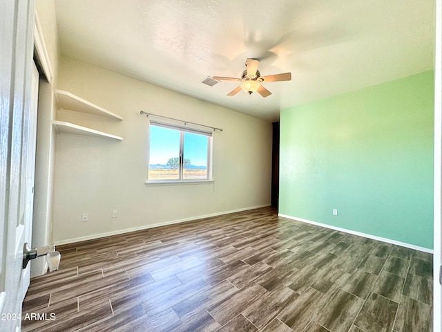 empty room featuring ceiling fan and dark hardwood / wood-style flooring