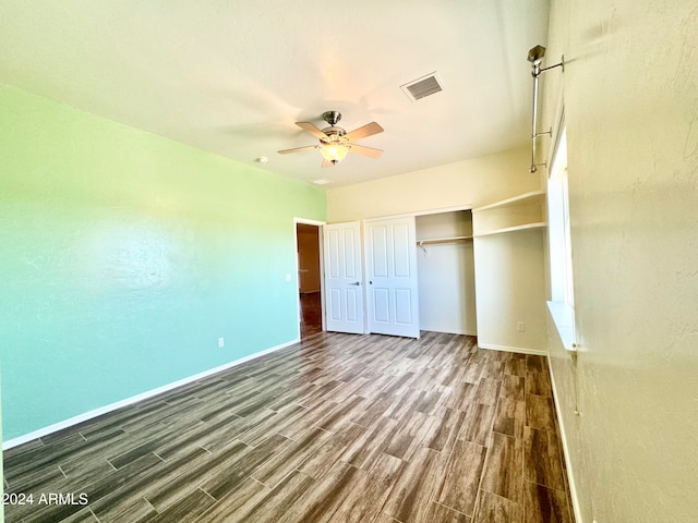 unfurnished bedroom featuring a closet, ceiling fan, and dark hardwood / wood-style floors