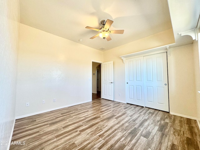 unfurnished bedroom featuring hardwood / wood-style floors and ceiling fan