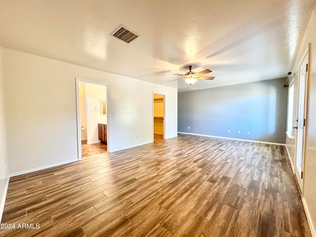 interior space with ceiling fan, wood-type flooring, and a textured ceiling