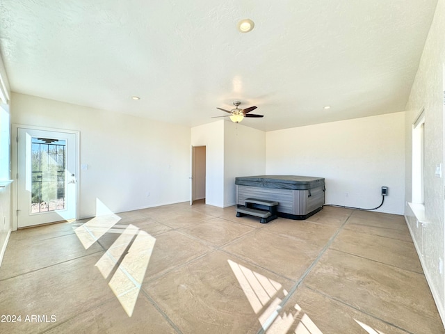 interior space with ceiling fan and a textured ceiling