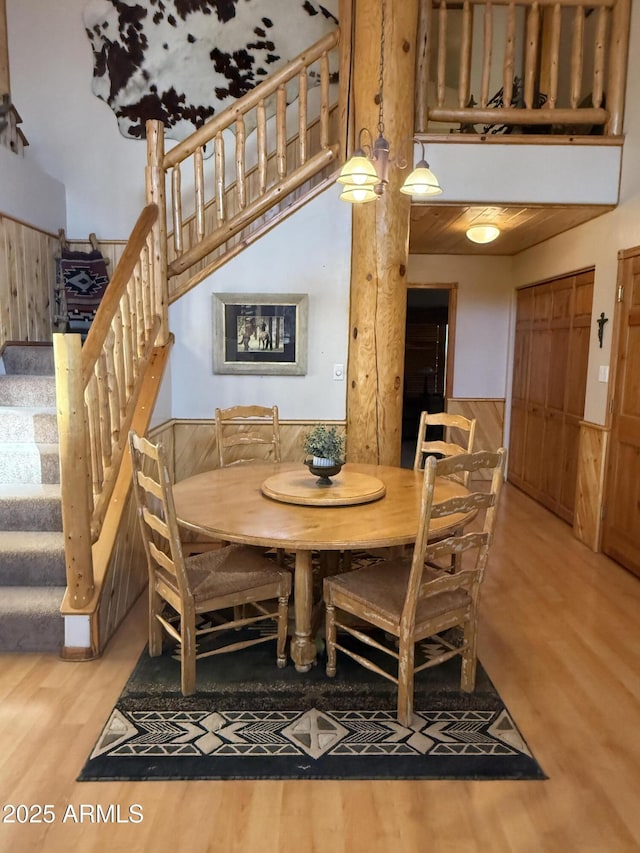 dining space featuring stairs, a high ceiling, and wood finished floors