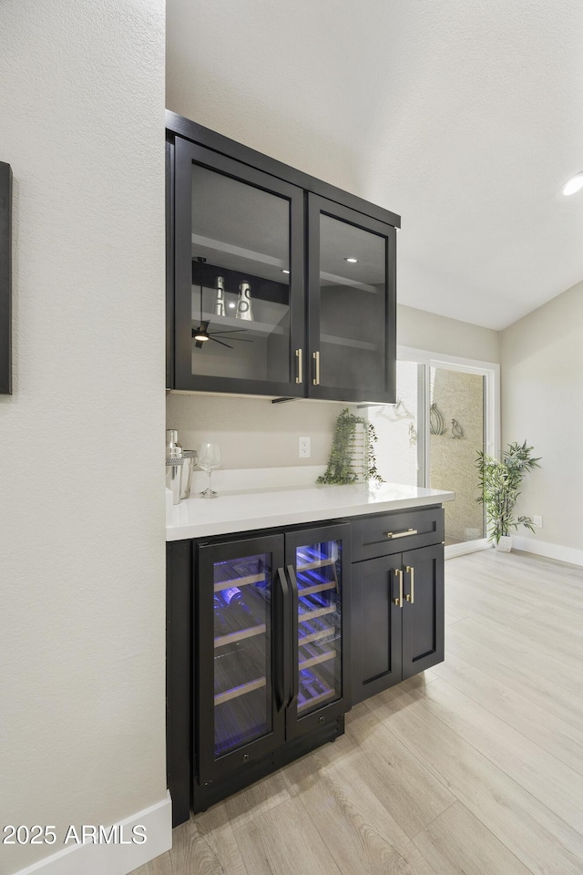 10538 E Gold Dust Cir, Scottsdale, AZ 85258 - indoor dry bar with beverage cooler, light wood finished floors, and recessed lighting