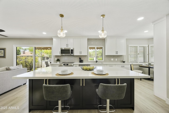 10538 E Gold Dust Cir, Scottsdale, AZ 85258 - kitchen featuring stainless steel appliances, light countertops, tasteful backsplash, white cabinets, and plenty of natural light