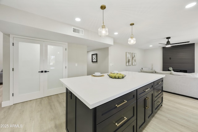 10538 E Gold Dust Cir, Scottsdale, AZ 85258 - kitchen featuring light wood finished floors, recessed lighting, light countertops, pendant lighting, and a kitchen island