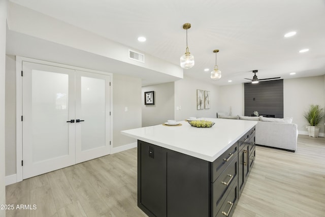 10538 E Gold Dust Cir, Scottsdale, AZ 85258 - kitchen with light wood-style flooring, a center island, recessed lighting, light countertops, and ceiling fan