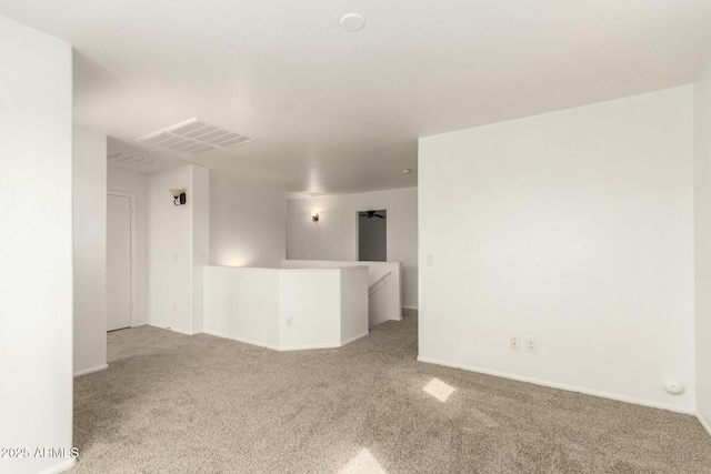 unfurnished room featuring visible vents and light carpet