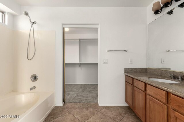 full bathroom with tile patterned floors, a spacious closet, vanity, and shower / tub combination