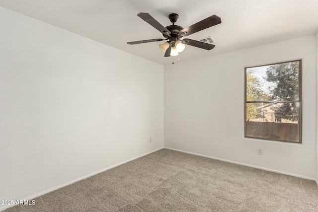 carpeted empty room featuring a ceiling fan, visible vents, and baseboards