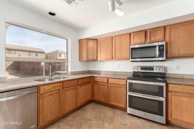 kitchen with visible vents, a sink, light countertops, light tile patterned floors, and stainless steel appliances