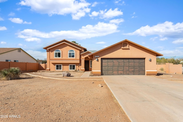 view of front of house with driveway, a garage, fence, and stucco siding