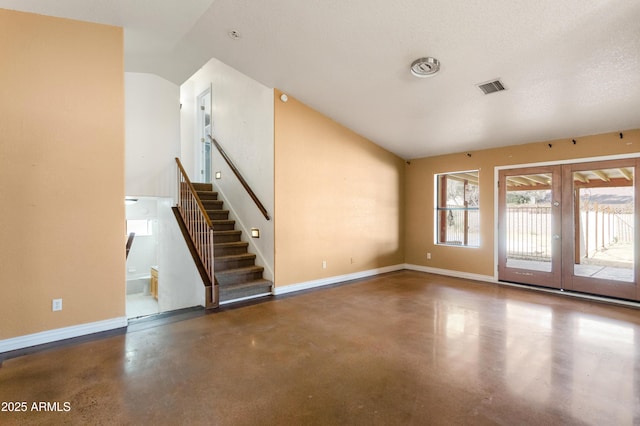 interior space with baseboards, visible vents, stairway, vaulted ceiling, and concrete floors