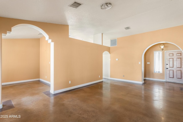 interior space featuring visible vents, arched walkways, and concrete flooring