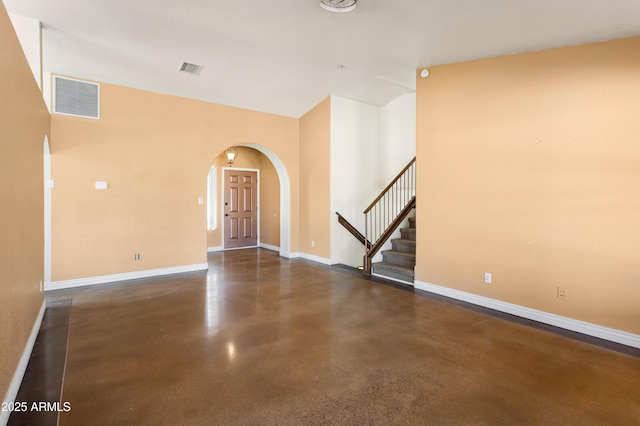 interior space featuring baseboards, stairs, visible vents, and arched walkways