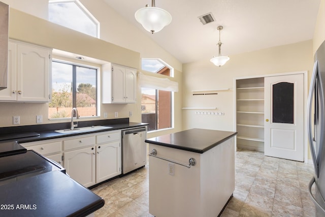 kitchen with stainless steel appliances, dark countertops, a sink, and visible vents