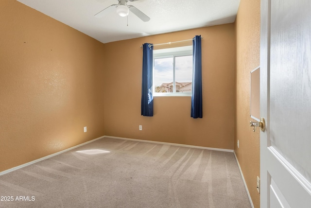 unfurnished room featuring carpet flooring, a ceiling fan, and baseboards