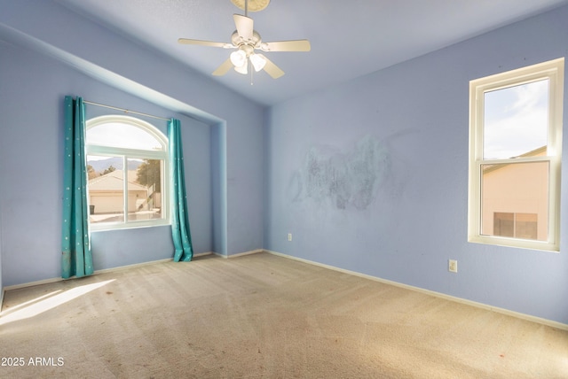 spare room featuring carpet floors, baseboards, and a ceiling fan