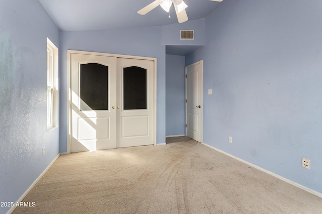 unfurnished bedroom featuring carpet, visible vents, vaulted ceiling, and baseboards