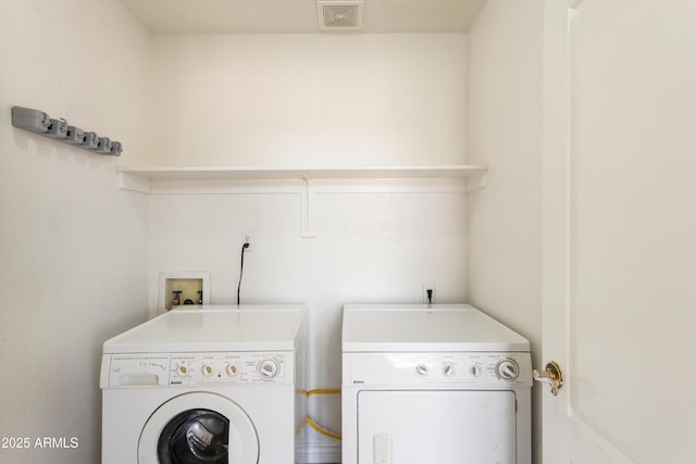 clothes washing area featuring laundry area, visible vents, and washer and dryer