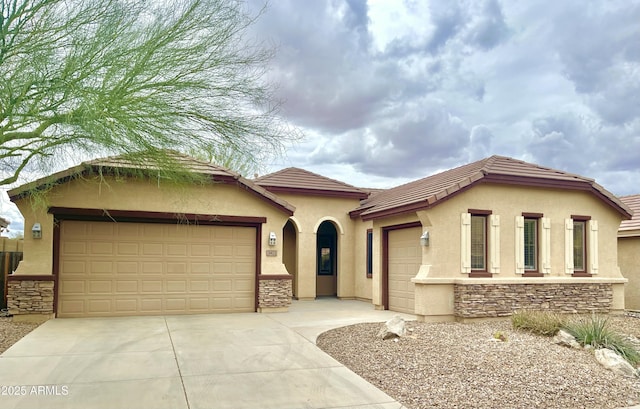 3421 W Warren Dr, Anthem, AZ 85086 - mediterranean / spanish-style house with driveway, a tile roof, stone siding, stucco siding, and an attached garage