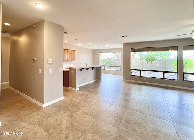 3421 W Warren Dr, Anthem, AZ 85086 - unfurnished living room featuring visible vents, baseboards, recessed lighting, a ceiling fan, and light tile patterned floors
