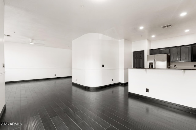 unfurnished living room with ceiling fan and dark hardwood / wood-style flooring