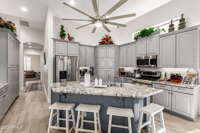 kitchen with stainless steel appliances, a ceiling fan, a sink, and gray cabinets