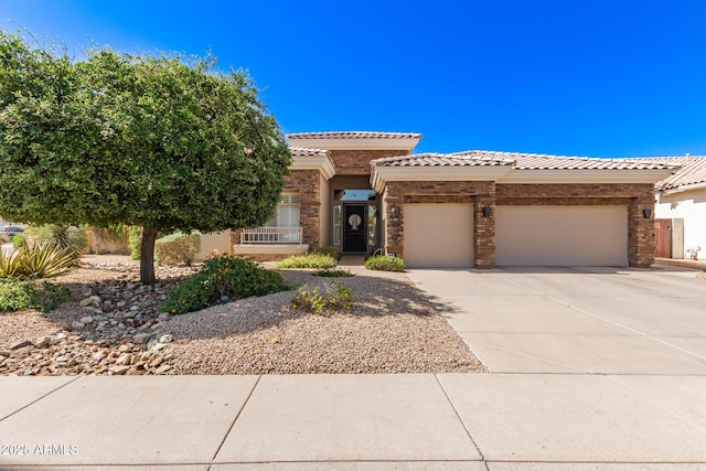 mediterranean / spanish-style house with driveway, a tile roof, an attached garage, stone siding, and stucco siding