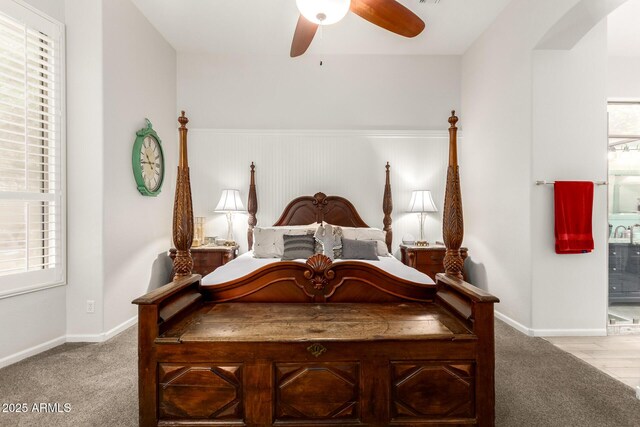 bedroom featuring baseboards, carpet flooring, arched walkways, and a ceiling fan