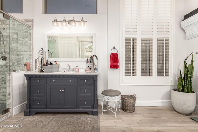 bathroom featuring baseboards, a stall shower, and wood finished floors