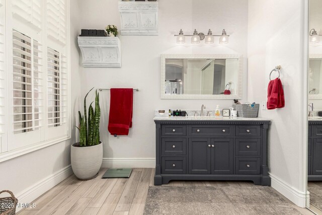bathroom featuring vanity, baseboards, and wood finished floors