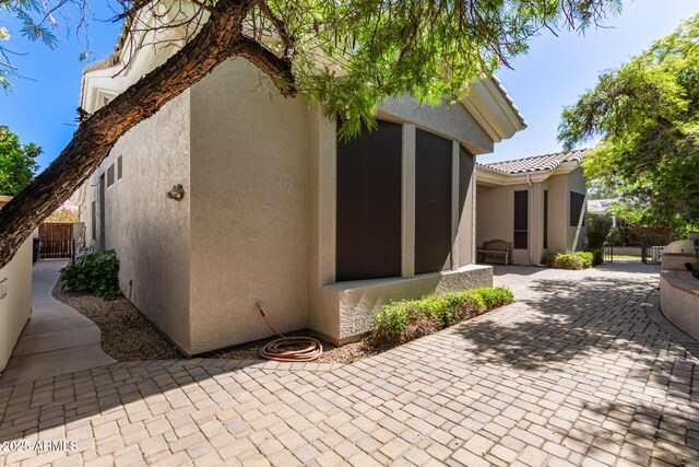 back of house featuring a patio, a gate, and stucco siding
