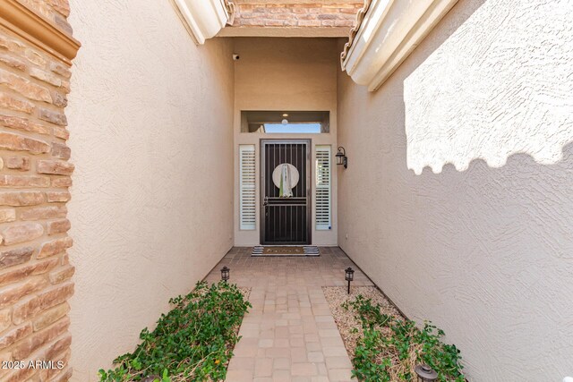 entrance to property featuring stucco siding