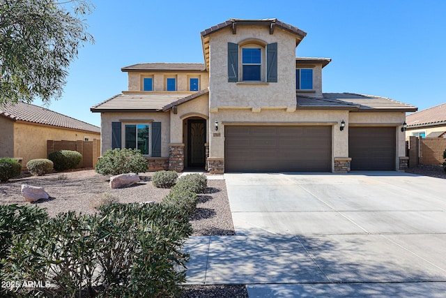 view of front of house with stone siding, fence, concrete driveway, and a tile roof