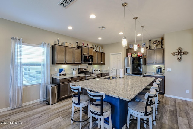 kitchen featuring a sink, visible vents, dark brown cabinetry, and appliances with stainless steel finishes
