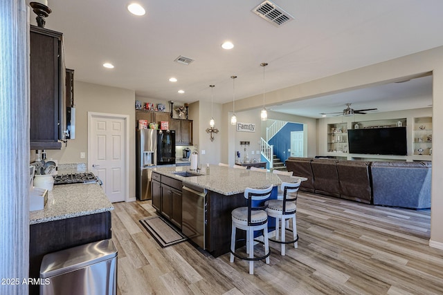 kitchen with a sink, visible vents, dark brown cabinetry, and appliances with stainless steel finishes
