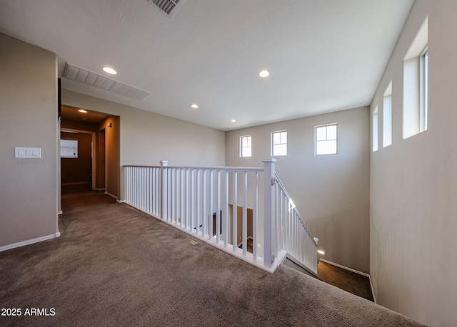 corridor featuring recessed lighting, visible vents, baseboards, and carpet