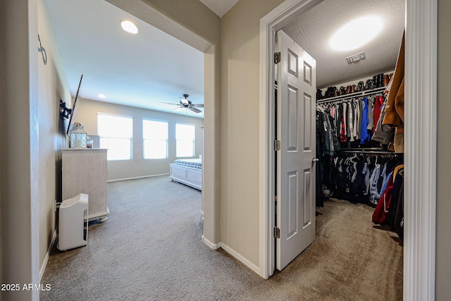 walk in closet with carpet flooring, visible vents, and ceiling fan