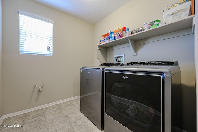 washroom with laundry area, baseboards, and washer and clothes dryer