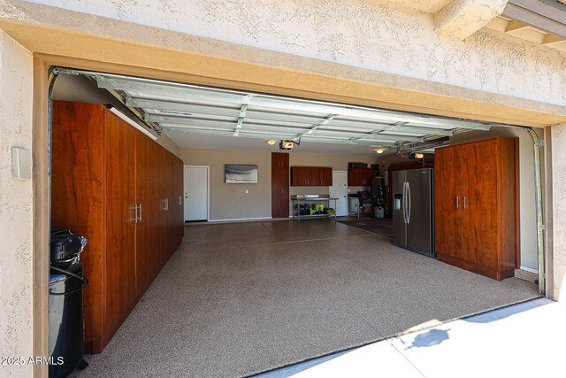 garage with a garage door opener and stainless steel fridge