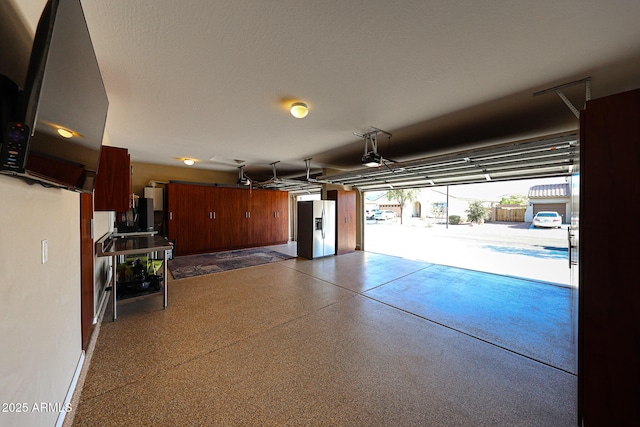 garage featuring a garage door opener and stainless steel fridge with ice dispenser