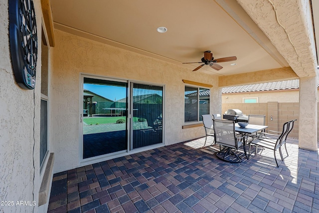 view of patio / terrace featuring grilling area, ceiling fan, outdoor dining space, and fence