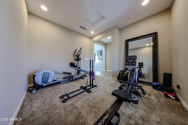 exercise room with visible vents, baseboards, attic access, and carpet flooring
