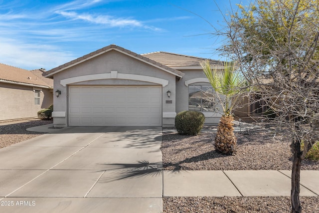 ranch-style house featuring concrete driveway, an attached garage, a tiled roof, and stucco siding